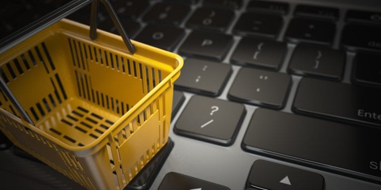 yellow shopping basket on laptop keyboard